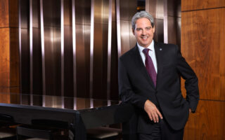 Guy Hutchinson, President and CEO of Rotana Hotels stands in front of wooden panelling