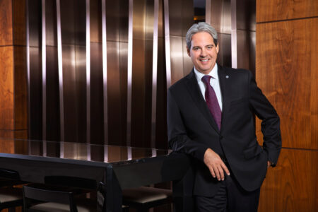 Guy Hutchinson, President and CEO of Rotana Hotels stands in front of wooden panelling