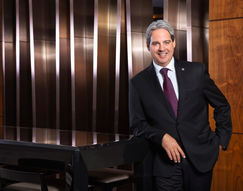 Guy Hutchinson, President and CEO of Rotana Hotels stands in front of wooden panelling