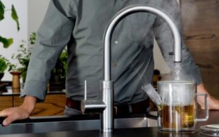 Torso in grey shirt behind a Quooker 3-in-1 tap