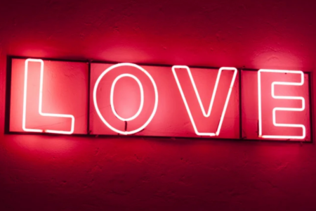 Bright neon sign that says LOVE n red light